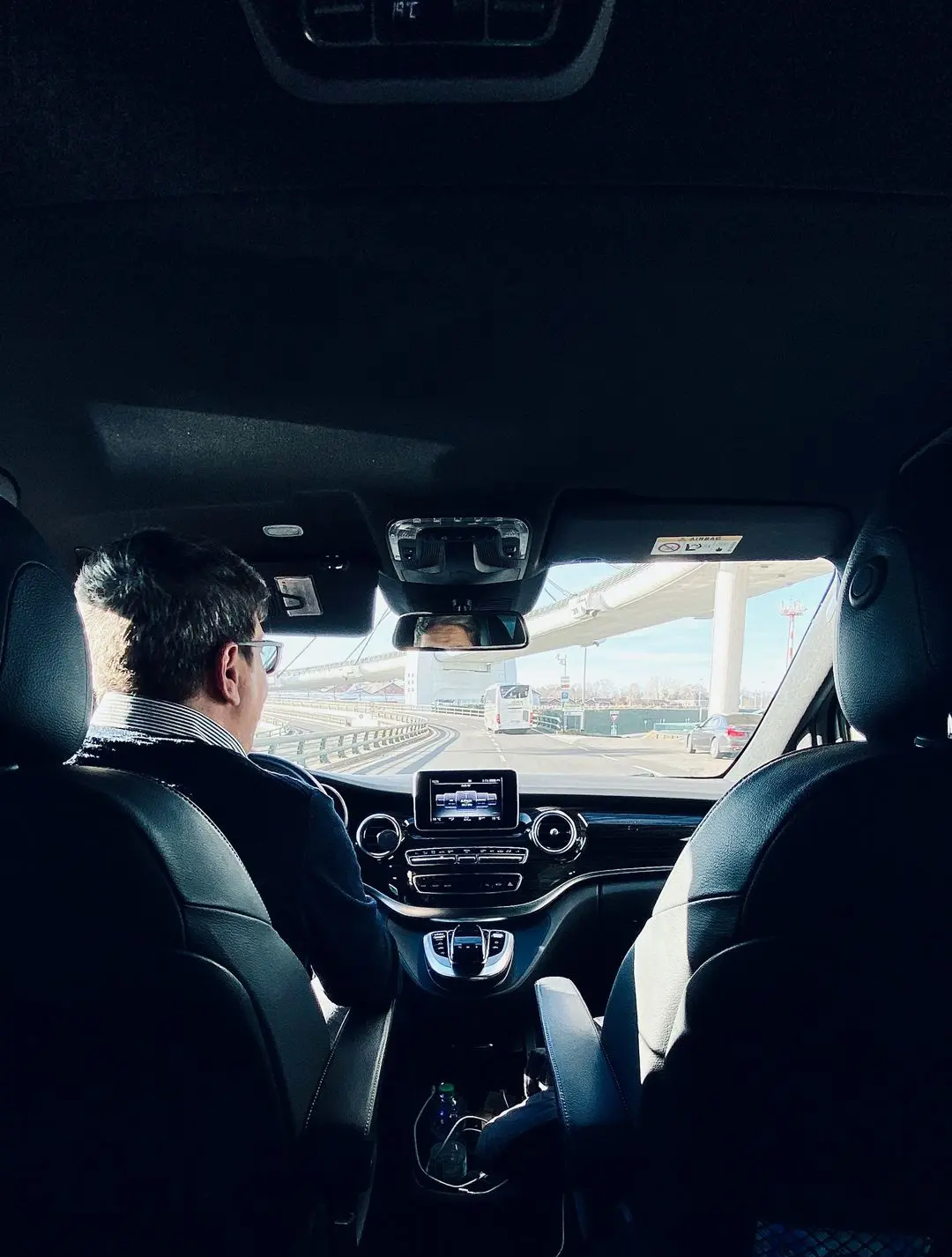 man in black suit driving car during daytime